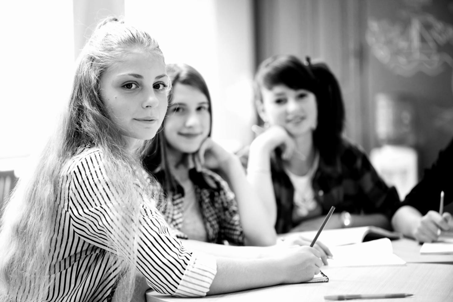 Traders participating in algorithm development workshop with multiple monitors showing market data and code